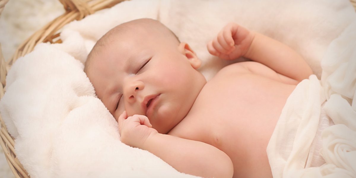 A New Born Baby Sleeping on White Bed in Basket