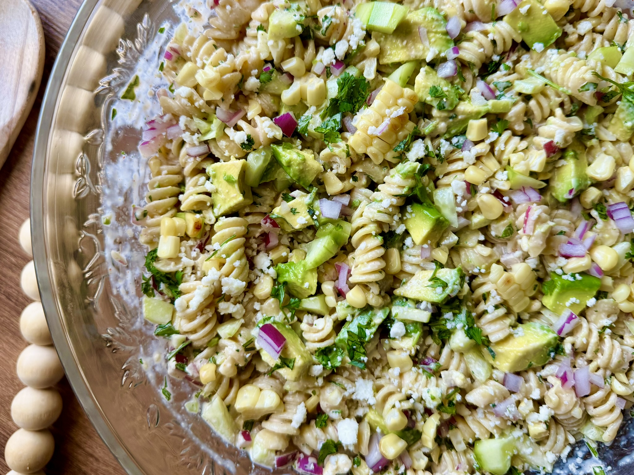 a large bowl with creamy cilantro lime pasta salad with avocados