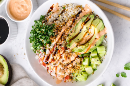 Crunch roll sushi bowl with imitation crab, avocado, cucumber, rice, crispy panko, spicy mayo, and eel sauce, served in a white bowl.