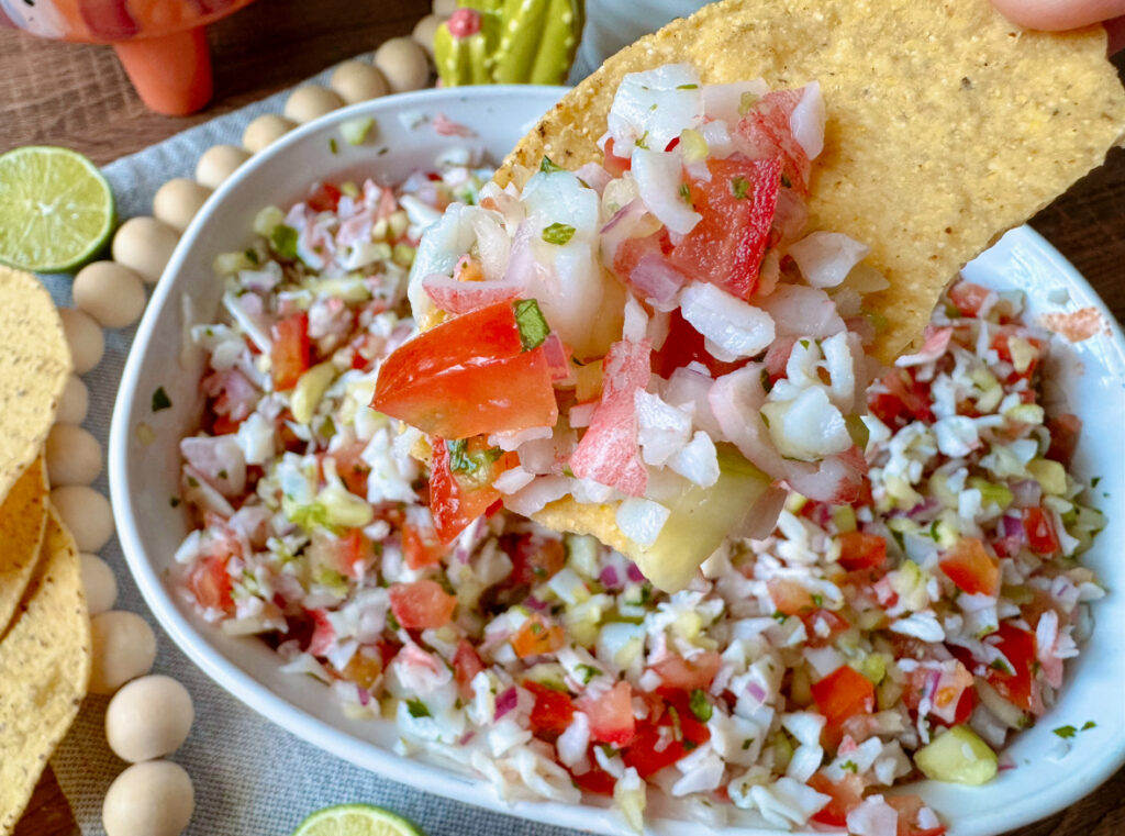 a tortilla chip up close with ceviche on top of it