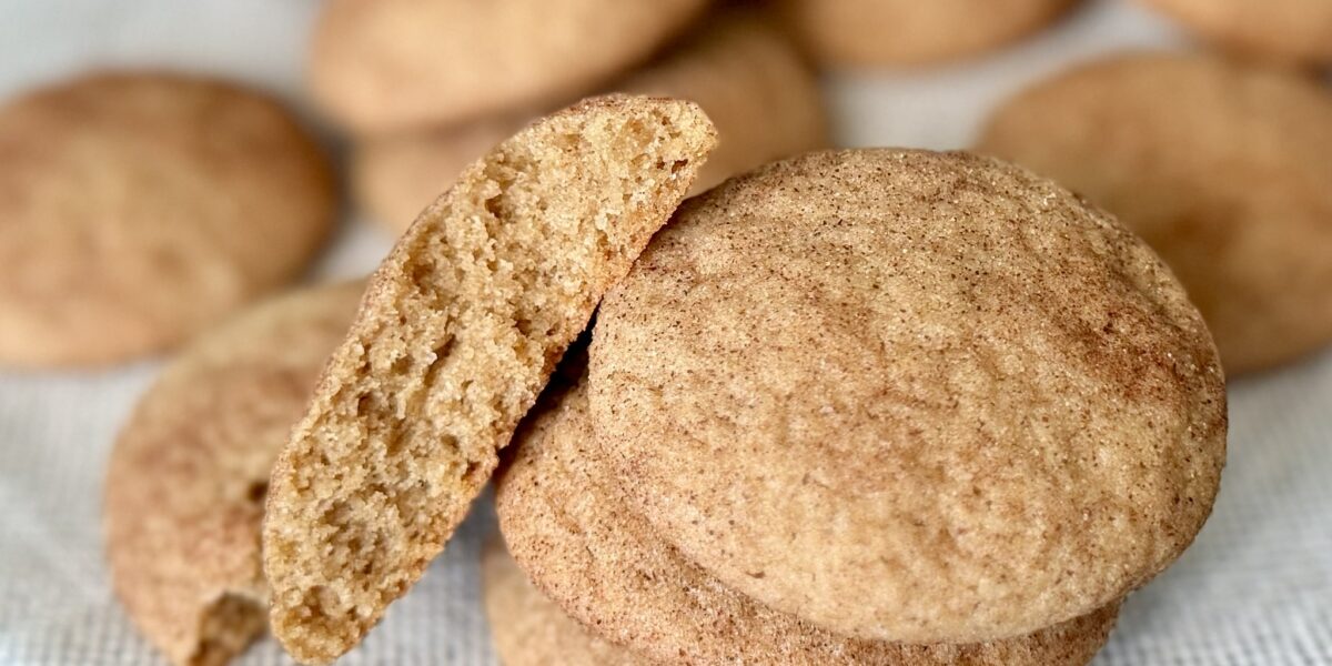 A stack of easy churro cookies with one split in half to show the softness inside.