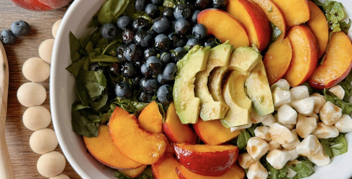 a colorful bowl of peach salad sitting on a table