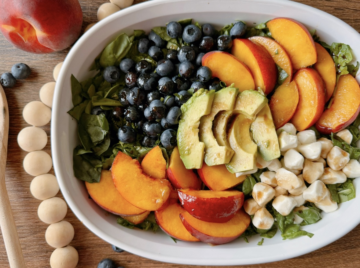 a colorful bowl of peach salad sitting on a table