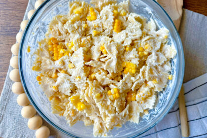 large clear glass bowl with corn pasta salad