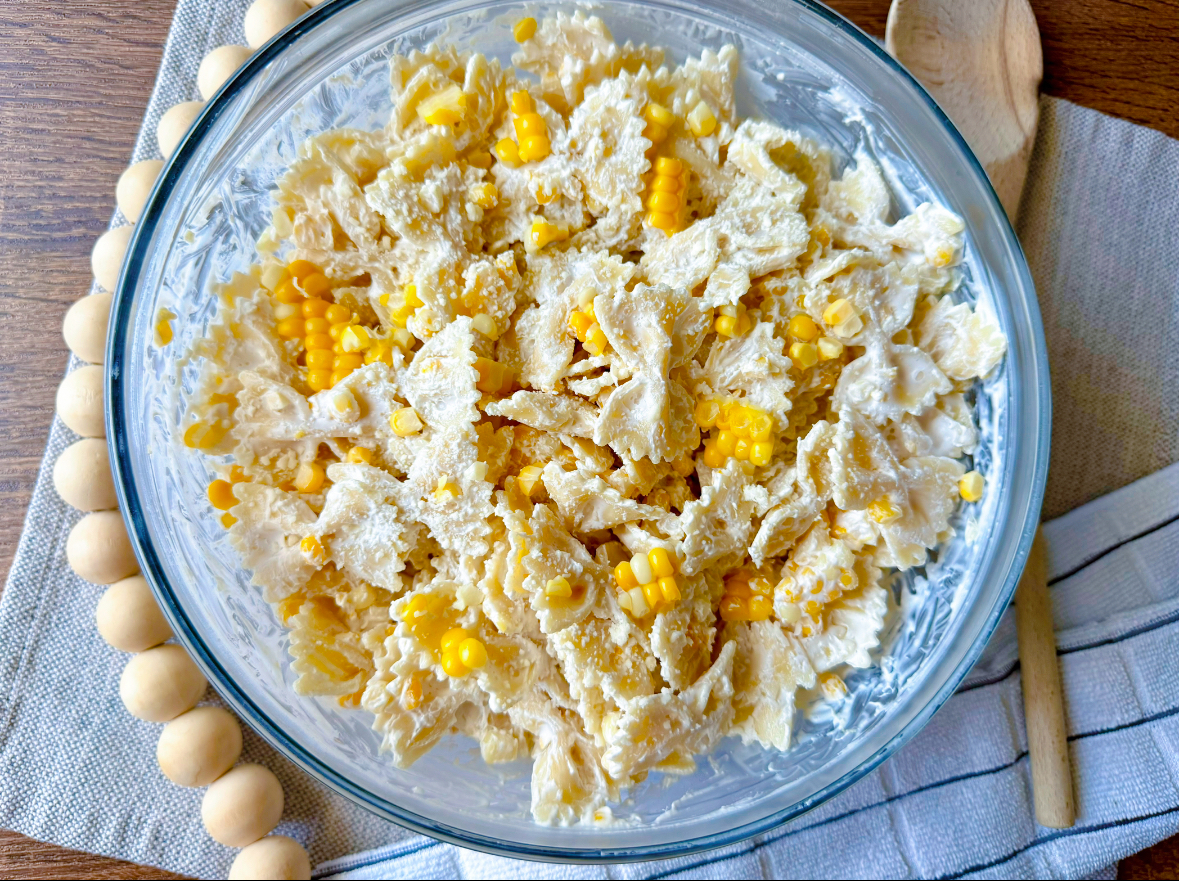 large clear glass bowl with corn pasta salad