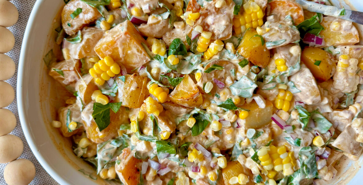 Chipotle potato salad in a large white bowl with colorful ingredients