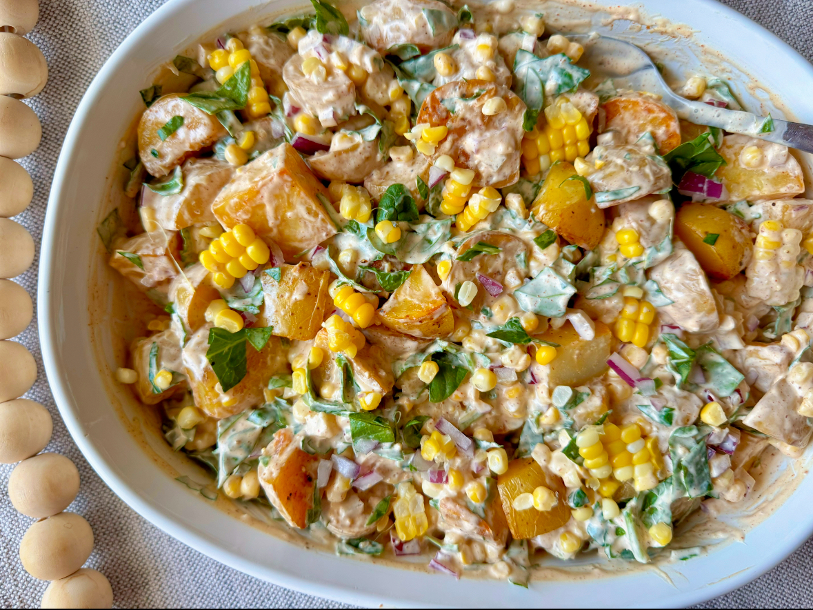 Chipotle potato salad in a large white bowl with colorful ingredients