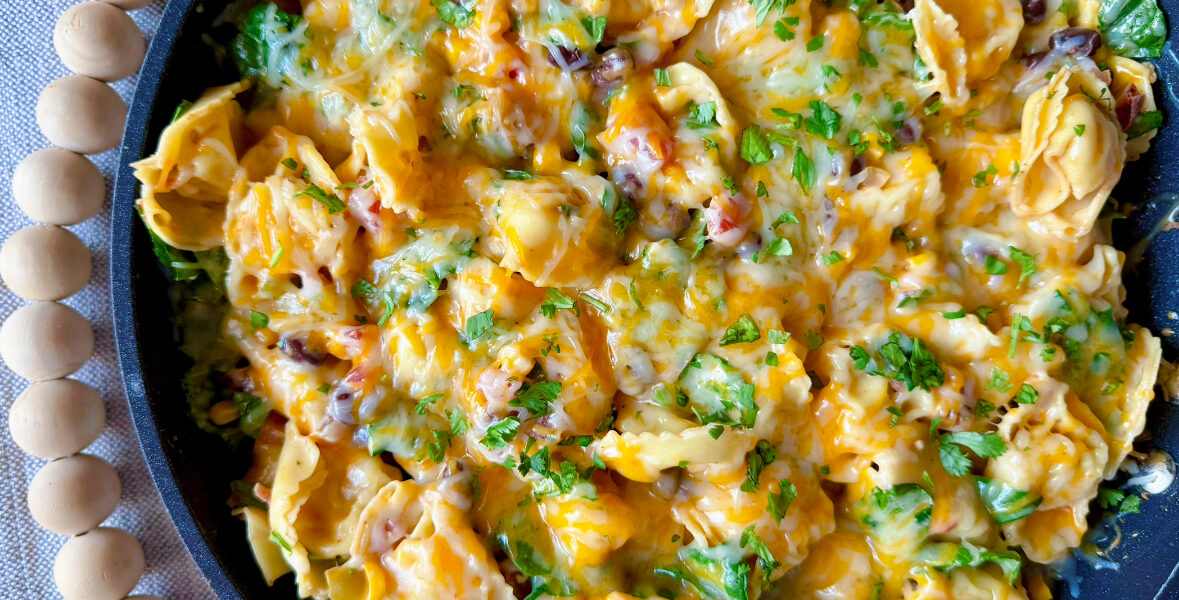 large skillet of southwest tortellini covered in cheese