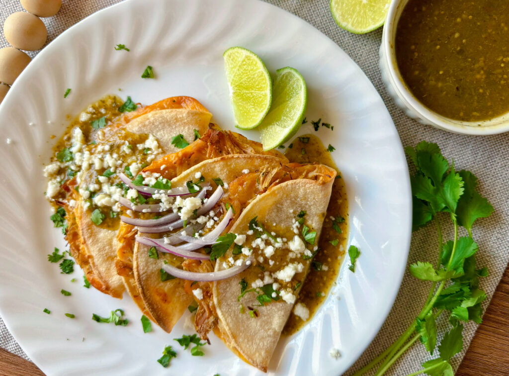 white plate with three baked tacos on top