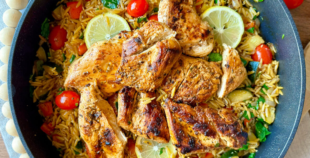 large skillet with mediterranean chicken orzo skillet on table