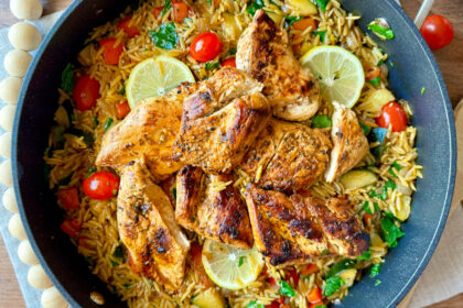 large skillet with mediterranean chicken orzo skillet on table