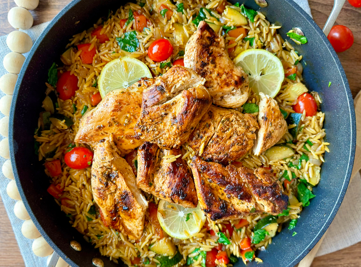 large skillet with mediterranean chicken orzo skillet on table