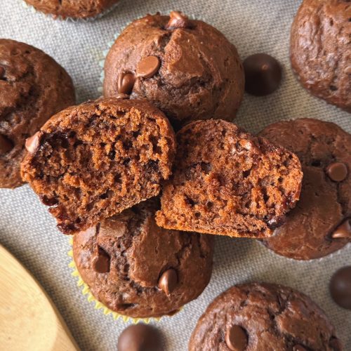 Detailed shot of a chocolate muffin split open to reveal its tender texture and gooey chocolate chips.