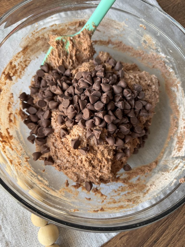 bowl of chocolate muffin batter with chocolate chips piled on top