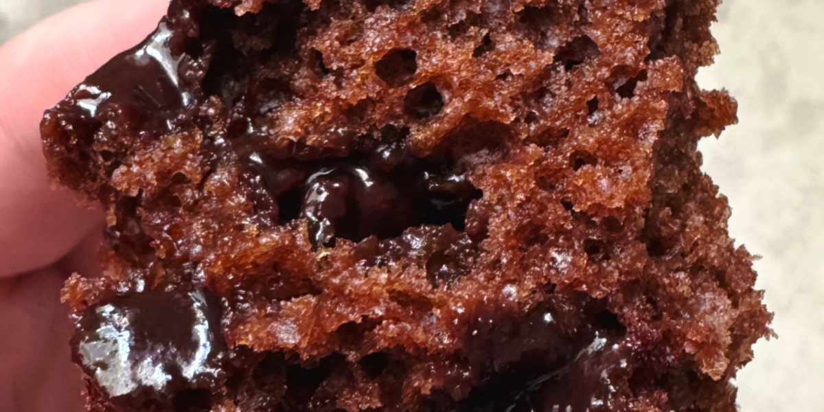 close up shot of a chocolate greek yogurt muffin cut in half with melty chocolate