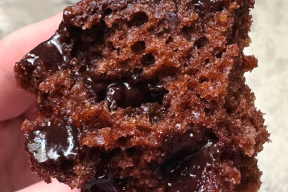 close up shot of a chocolate greek yogurt muffin cut in half with melty chocolate