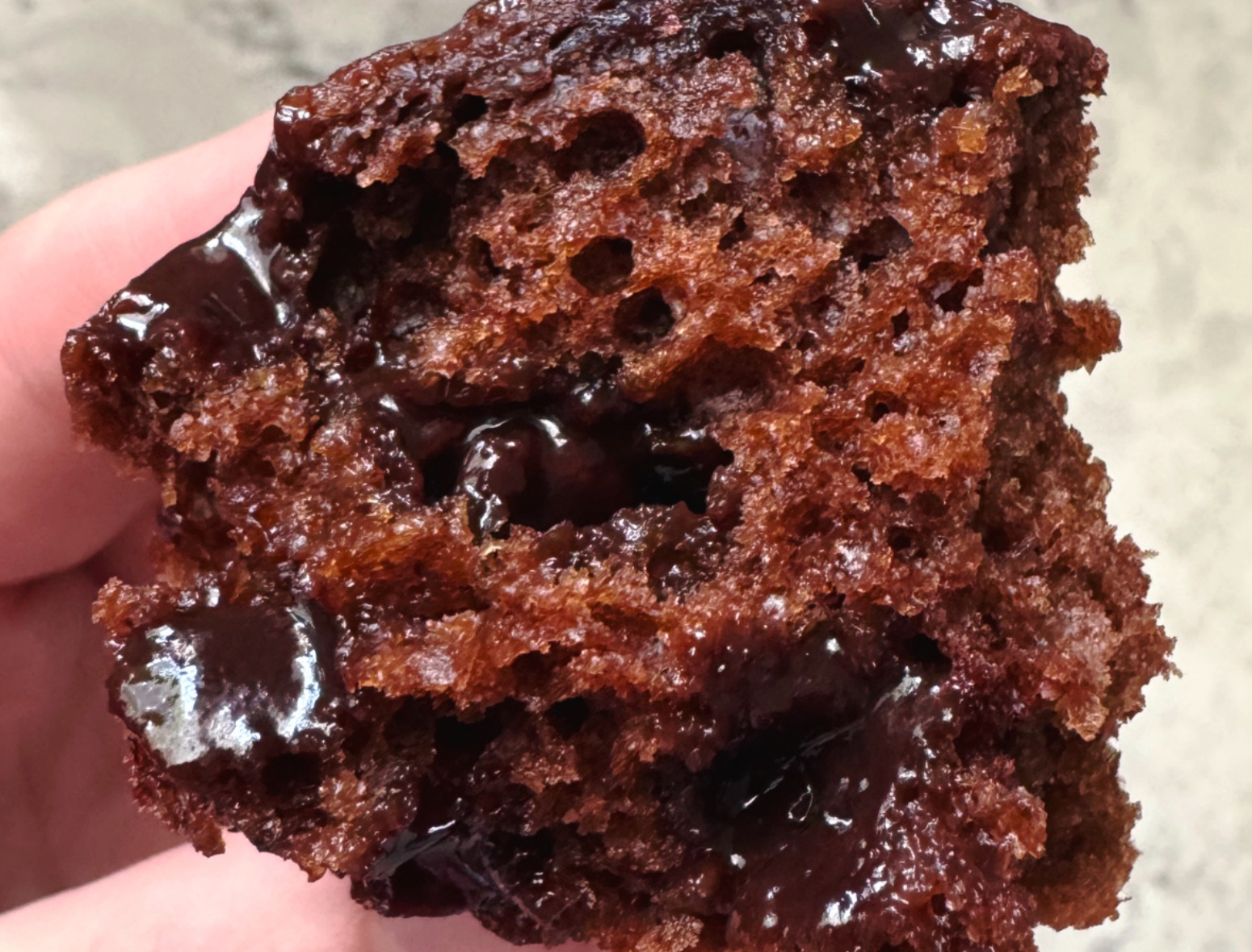 close up shot of a chocolate greek yogurt muffin cut in half with melty chocolate