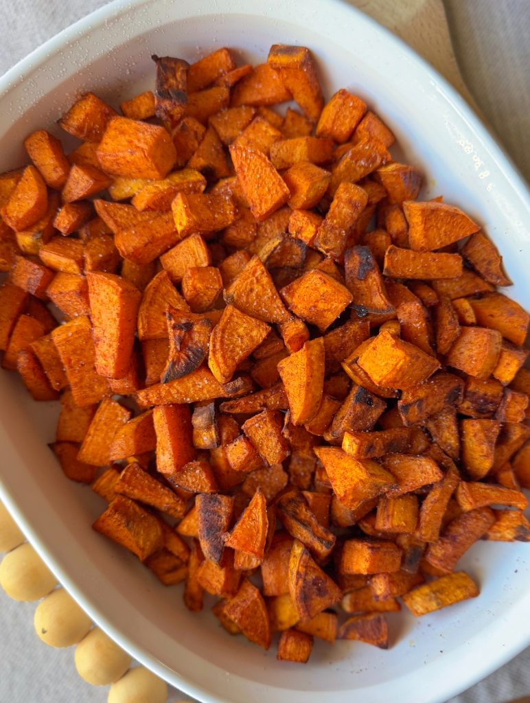 delicious roasted sweet potatoes tossed in cinnamon and paprika in a large serving dish