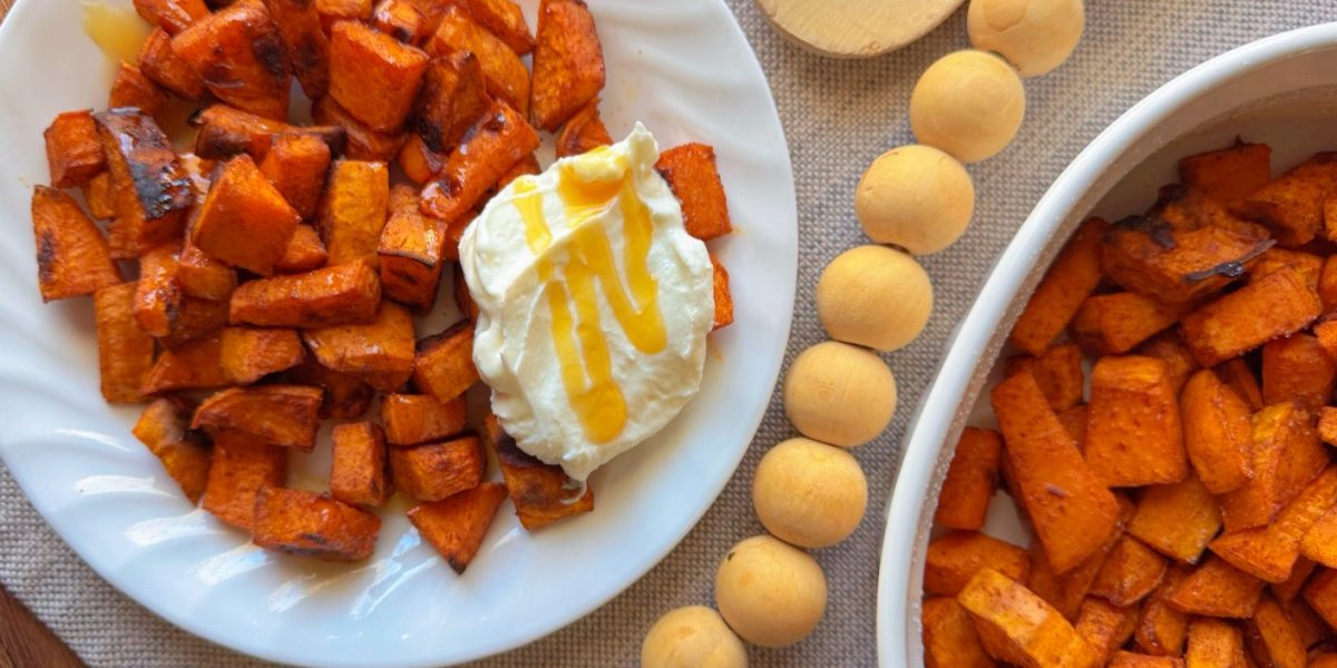 bowl of roasted sweet potatoes with greek yogurt and a drizzle of hot honey