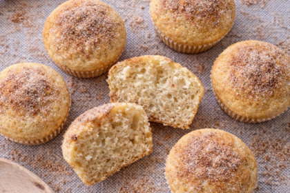 fluffy churro kodiak protein muffins on a mat with one cut in half to show soft texture inside