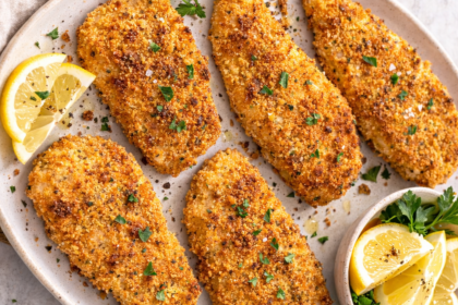 large white serving tray with crispy oven fried chicken garnished with lemon and parsley