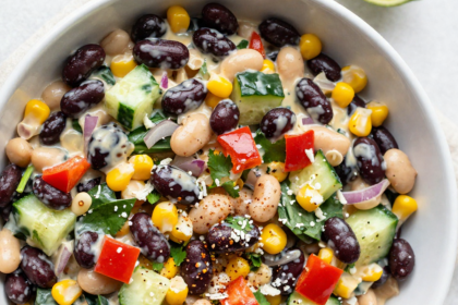 Overhead view of creamy chipotle bean salad with black beans, white beans, corn, and fresh vegetables in a Greek yogurt dressing.
