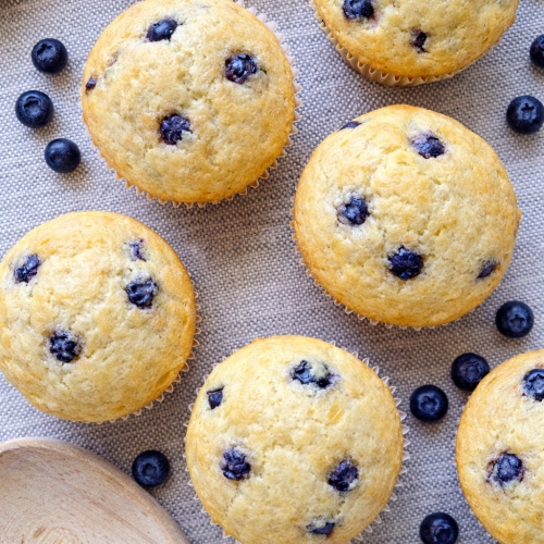 Lemon blueberry Greek yogurt muffins baked until golden with fresh blueberries throughout.