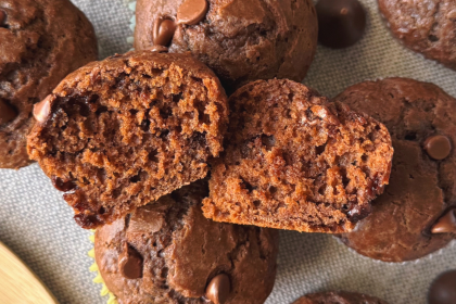 overhead shot of double chocolate greek yogurt muffins with one cut in half to show soft texture inside