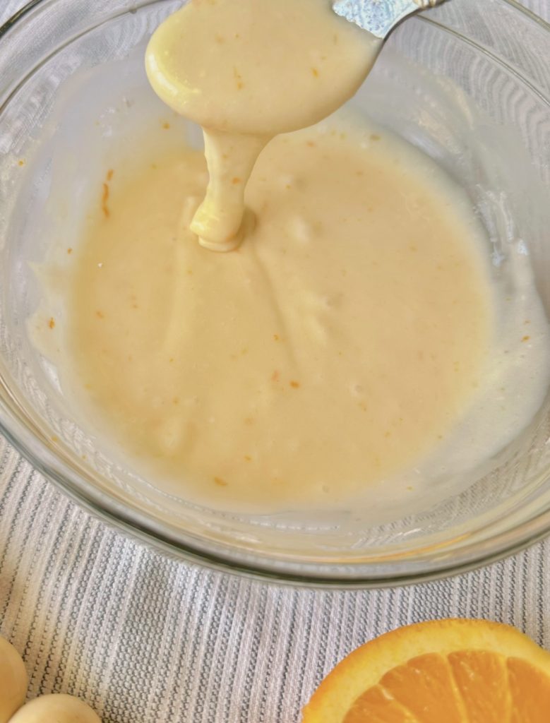 close up of orange vanilla glaze in a clear bowl