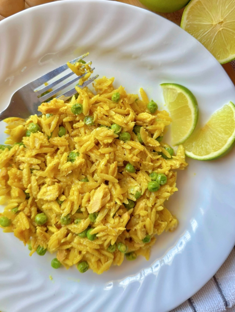 overhead shot of a white plate with a serving of curry orzo with tuna and peas
