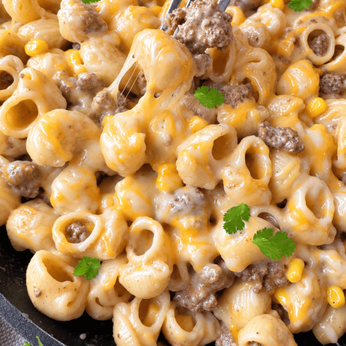 close up of creamy chipotle lime beef pasta with a fork pulling a cheesy bite