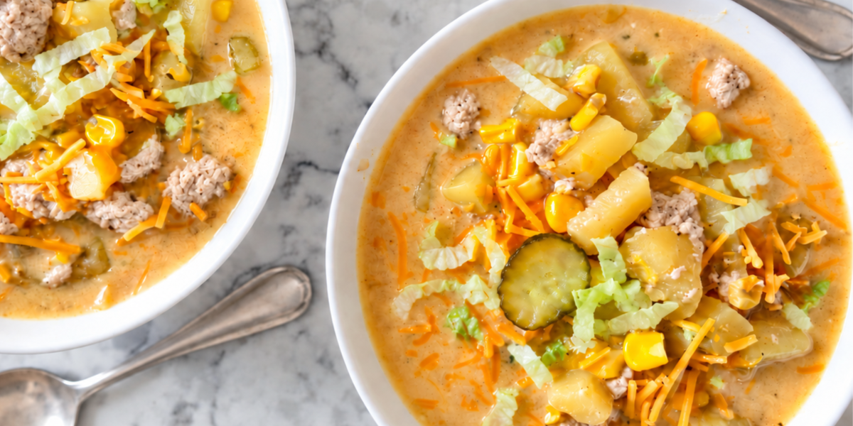 two bowls on a white marble countertop with turkey cheeseburger soup in each one