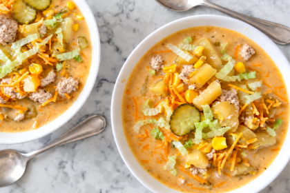two bowls on a white marble countertop with turkey cheeseburger soup in each one