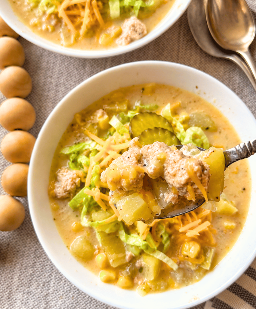 close up of a spoonful of turkey cheeseburger soup with large pieces of ground turkey and potatoes